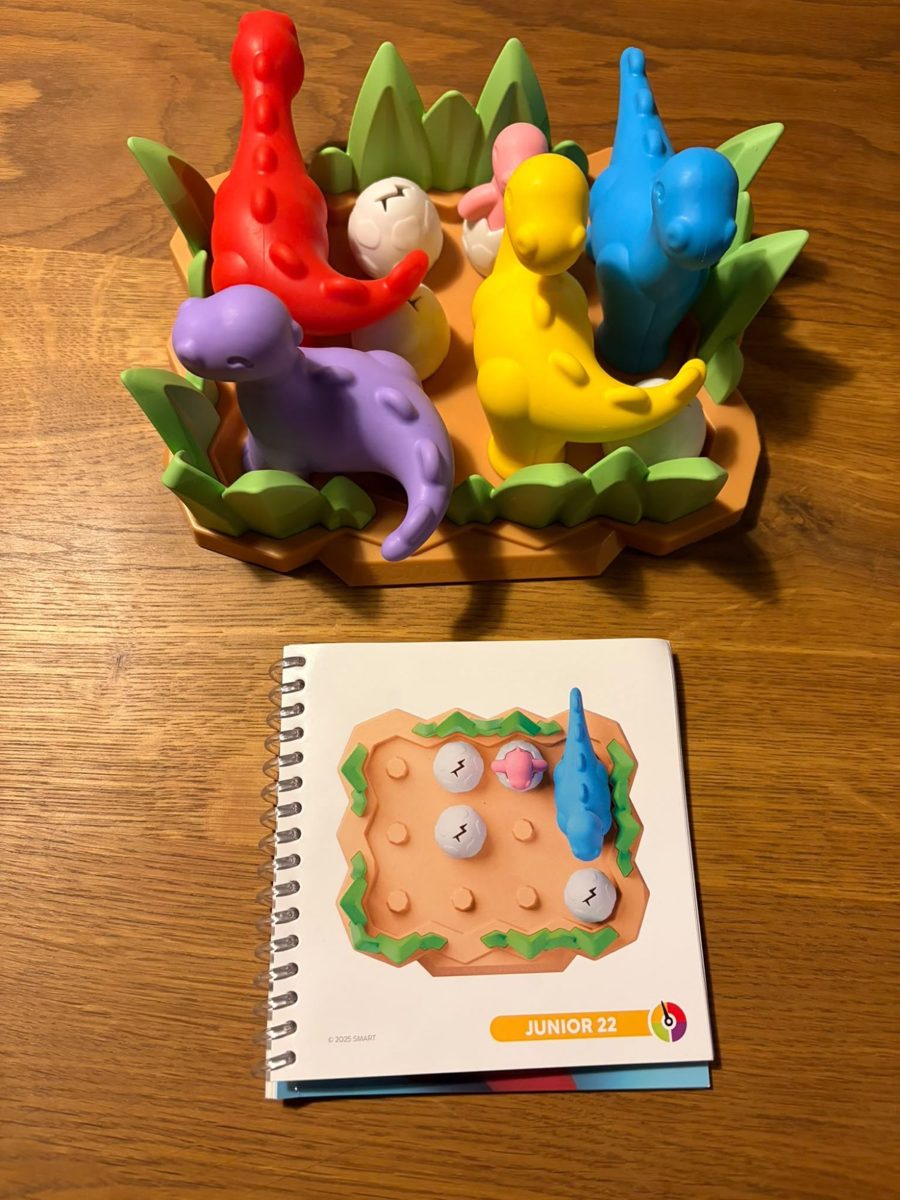 Een opdracht uit het boekje naast het spelbord met alle dino's erop